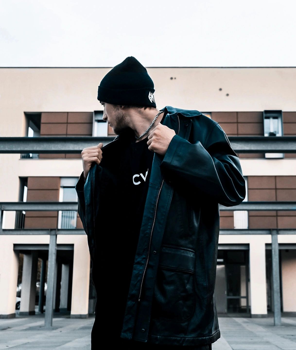 Man in black beanie and denim jacket in urban setting